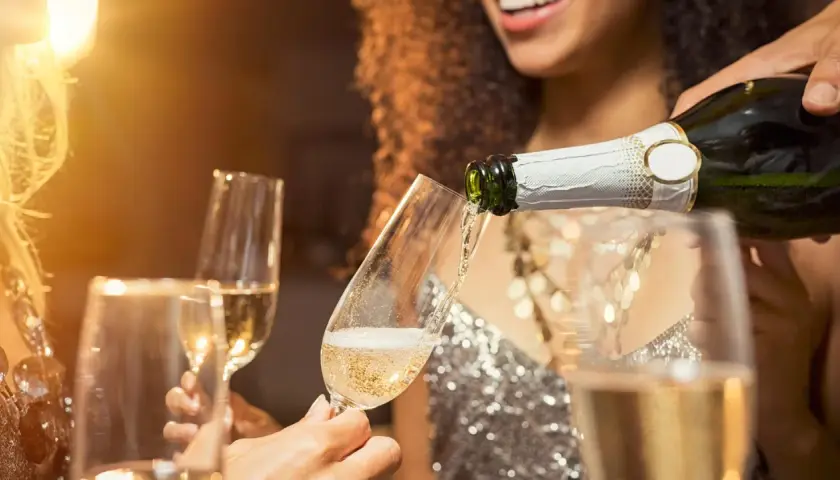Sekt wird in Gläser gegossen. Die Frage, was ist der Unterschied zwischen Sekt und Champagner, beschäftigt viele Genießer.