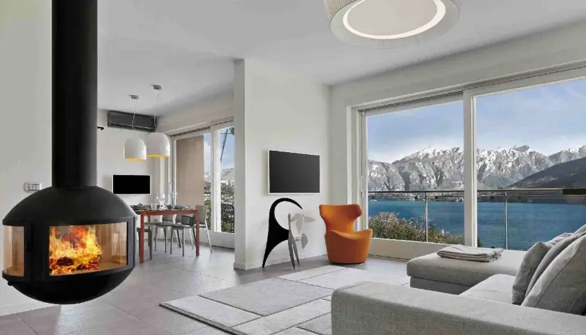 Nowoczesna koza do salonu z widokiem na góry i jezioro. Ciepło ognia i piękno natury w jednym.