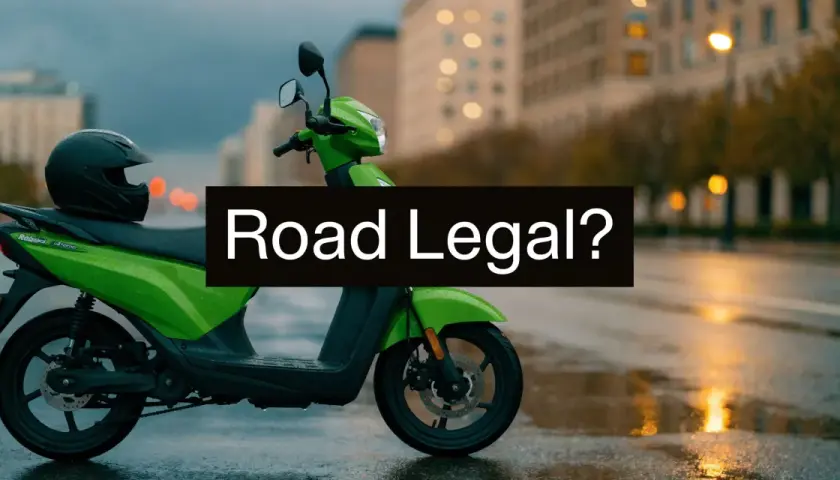Zielony motorower z kaskiem na siedzeniu, stojący na mokrej ulicy. Czy to motorower co to, legalny na drogach?
