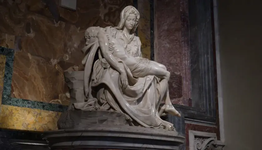 Pieta Michała Anioła: Matka Boska tuli martwe ciało Jezusa. Marmurowa rzeźba pełna bólu i piękna.