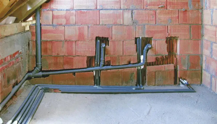 Instalacja hydrauliczna w trakcie budowy. Widoczne rury kanalizacyjne i wodne, z uwzględnieniem minimalny spadek dla rury 160.