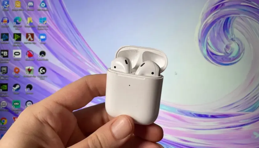 Jak podłączyć AirPods do komputera Windows? Białe słuchawki w etui, gotowe do sparowania z PC.