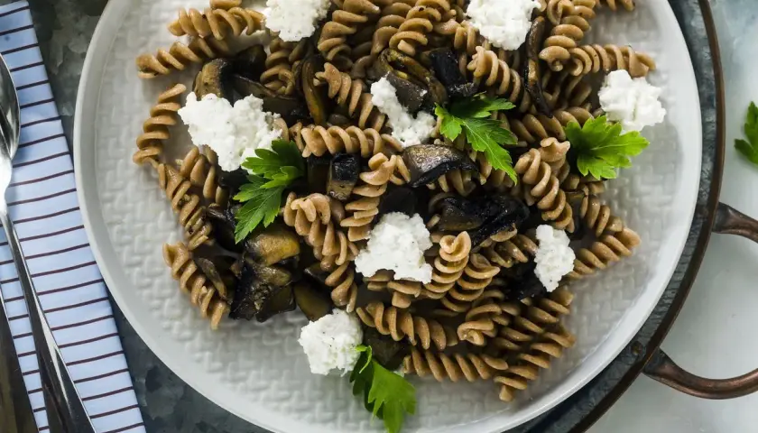 Fusilli integrali con melanzane grigliate, ricotta fresca e prezzemolo. Un piatto estivo leggero e gustoso.
