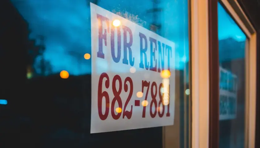 Szyba z napisem "FOR RENT" i numerem telefonu. Czy to dzierżawa, czy najem? Zadzwoń i się dowiedz!