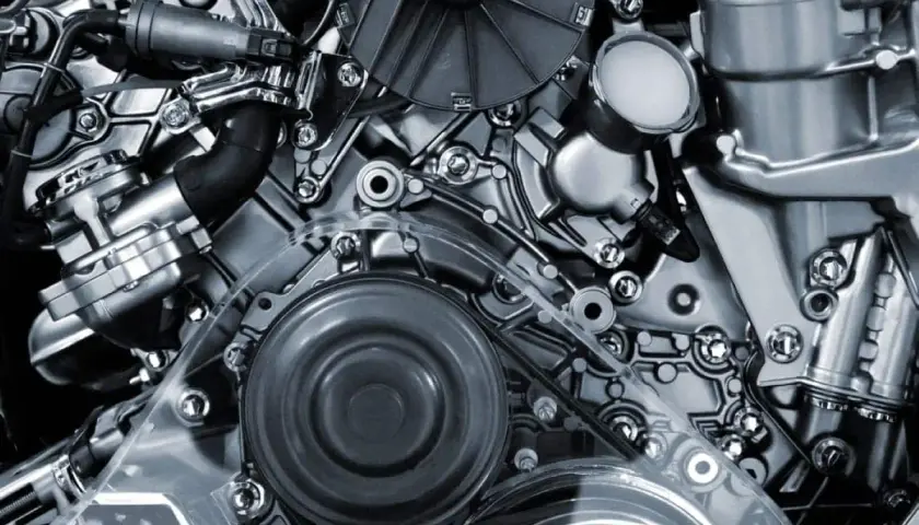 Detalle de un motor de motos 4 cilindros, con correas, poleas y componentes metálicos pulidos.