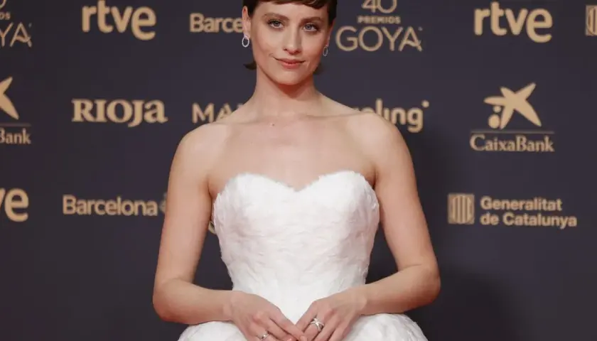 Una actriz posa en la goya alfombra roja con un vestido blanco voluminoso.