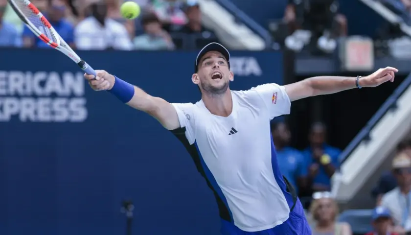 Dominic Thiem w akcji, uderza piłkę rakietą na korcie tenisowym.