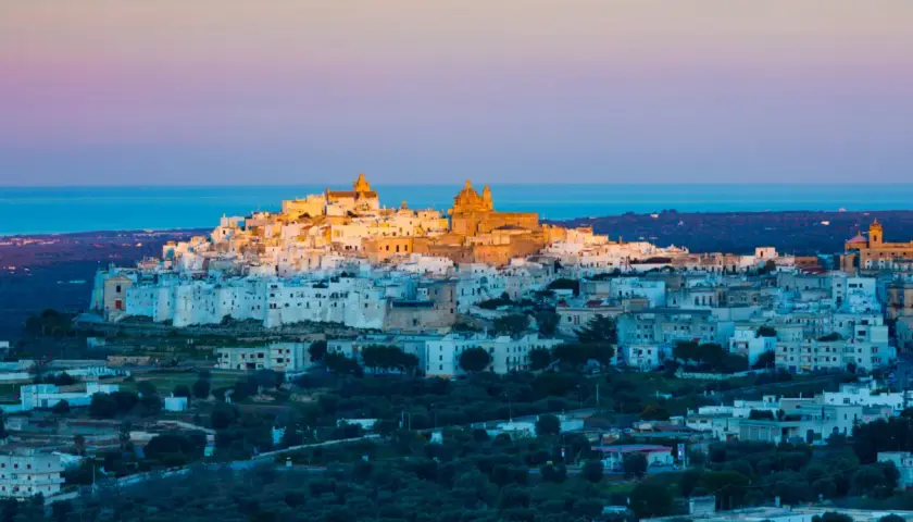 Ostuni, the "White City," glows at sunset, a beautiful destination near the closest airport to Puglia, Italy.