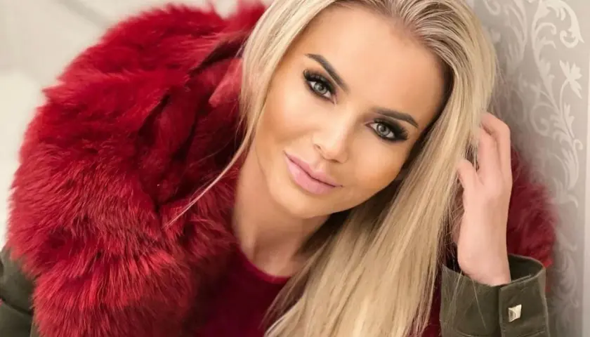 Monika Chwajoł w stylowej, czerwonej kurtce z futrem. Jej mąż z pewnością docenia jej modowy gust.