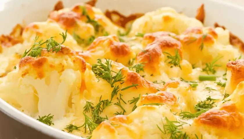 Coliflor al horno gratinada con queso y hierbas frescas. Un plato reconfortante y delicioso.