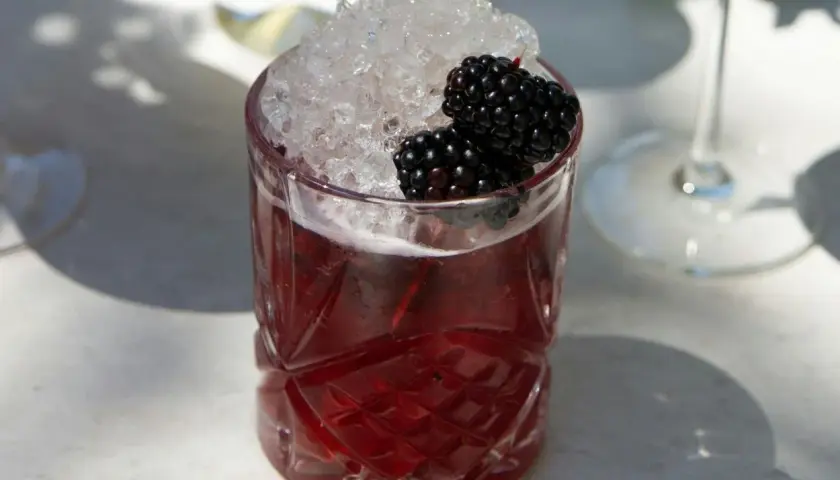 Ein erfrischender Drink mit zerstoßenem Eis und Brombeeren. Perfekt für einfache Cocktails an einem sonnigen Tag.