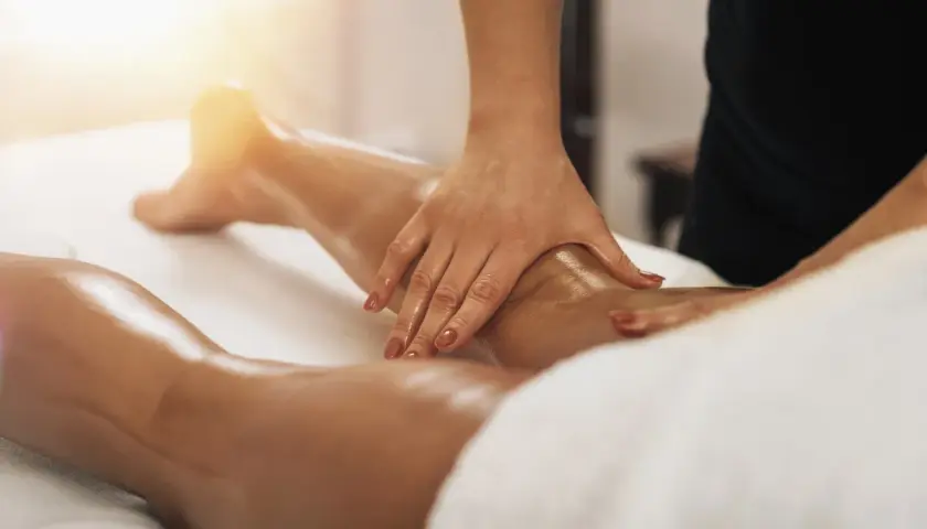 Massage des jambes pour aider à la circulation lymphatique. Un soin qui montre à quoi sert la lymphe pour le bien-être.