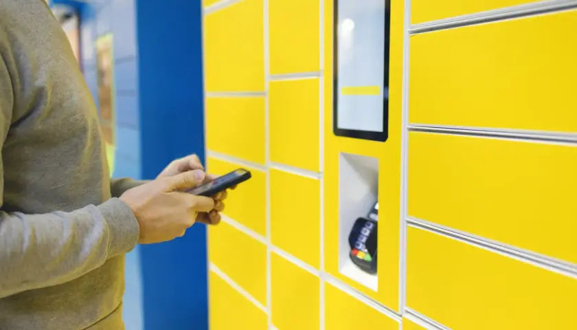 Mężczyzna używa aplikacji InPost Mobile do obsługi paczkomatu.
