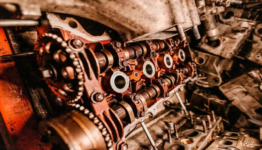 Primer plano de un motor de coche con engranajes y levas, mostrando las piezas de desgaste de un coche.