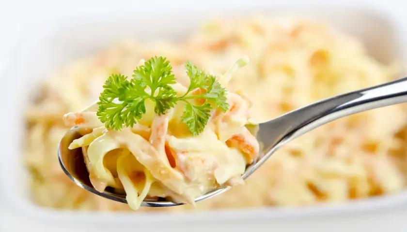 Ein Löffel cremiger Coleslaw Salat, garniert mit Petersilie. Perfekt für ein einfaches coleslaw salat rezept.