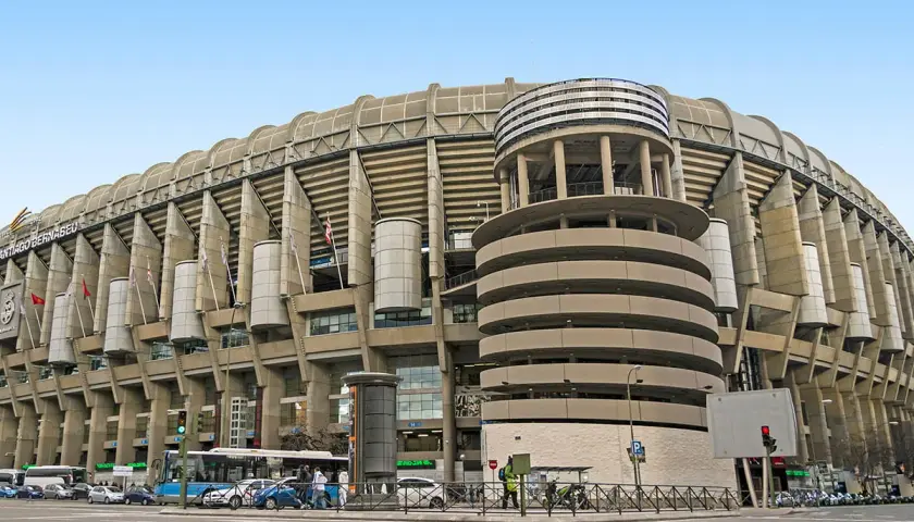 Imponujący stadion Realu Madryt, Santiago Bernabéu, z charakterystyczną betonową fasadą i okrągłą wieżą.