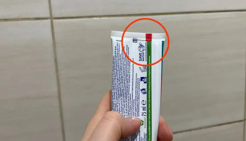 Czerwony pasek na tubce pasty do zębów informuje, że opakowanie jest wykonane z materiału, który można poddać recyklingowi.