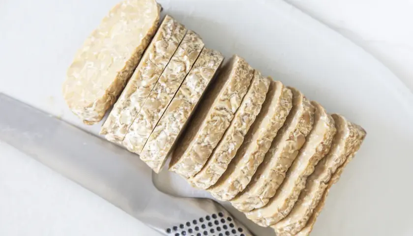 Pokrojony w plastry tempeh, czyli fermentowana soja, gotowy do smażenia. To świetna alternatywa dla mięsa.