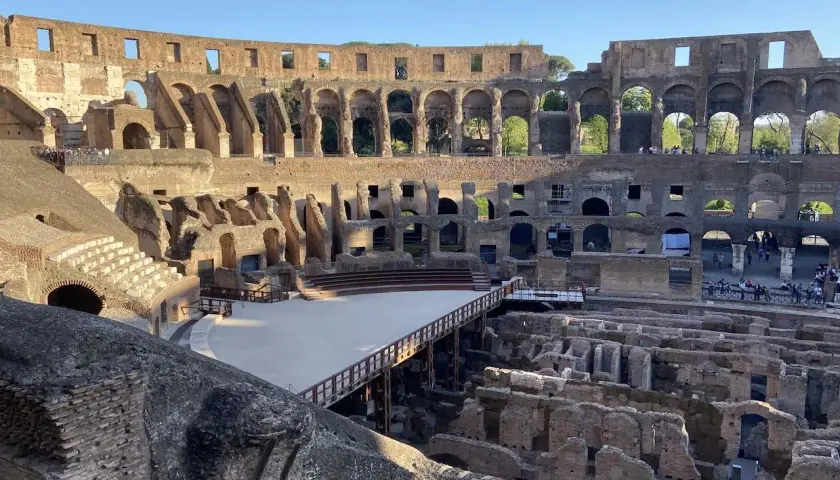 Intérieur du Colisée, vestiges de l'arène et des gradins. Un pont en bois traverse l'espace. Vérifiez l'horaire du Colisée pour votre visite.