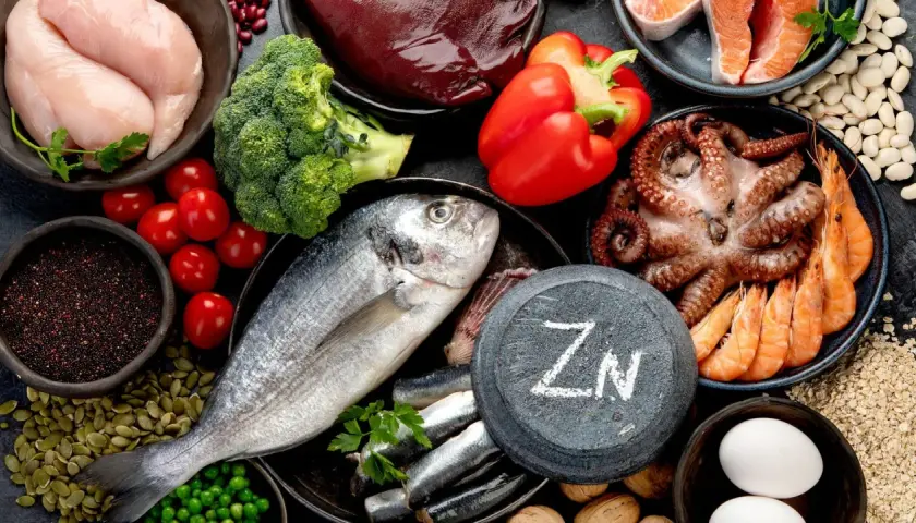 Zink ist wichtig für das Immunsystem. Auf dem Bild sind zinkreiche Lebensmittel wie Fisch, Meeresfrüchte, Huhn, Leber, Nüsse und Samen zu sehen.