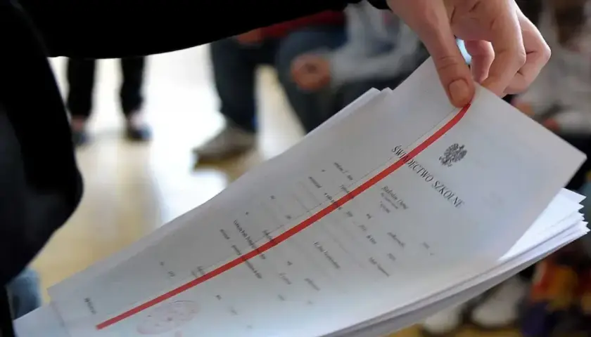 Dłoń trzyma świadectwo szkolne. Zastanawiasz się, czy religia wlicza się do średniej?