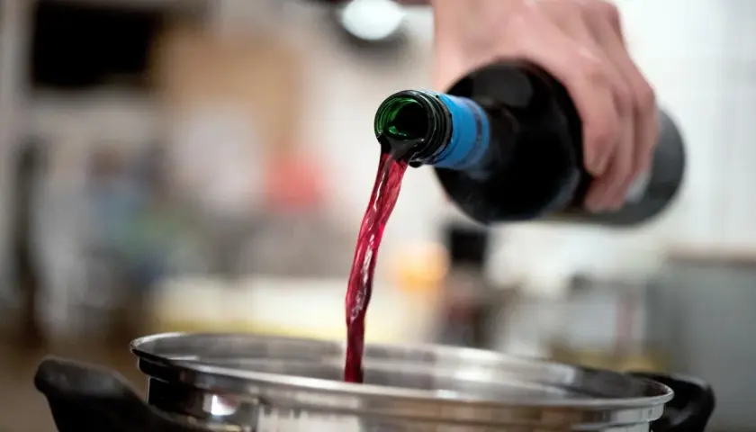 Rotwein wird in einen Topf gegossen. Beim Kochen verdunstet Alkohol.
