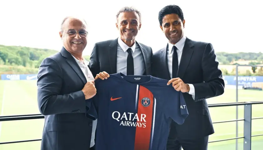 Luis Enrique, nowy trener PSG, prezentuje koszulkę klubu z prezesem i dyrektorem sportowym.
