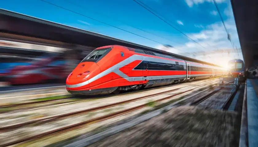 Train rouge vif filant sur les rails, prêt pour un voyage rapide entre Rome et Naples.