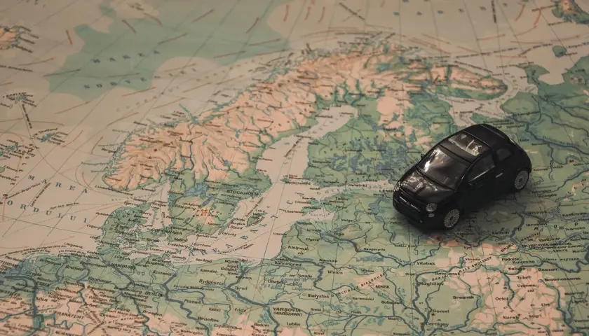 Une petite voiture noire sur une carte d'Europe. Idéal pour une musique à mettre dans sa playlist de road trip.