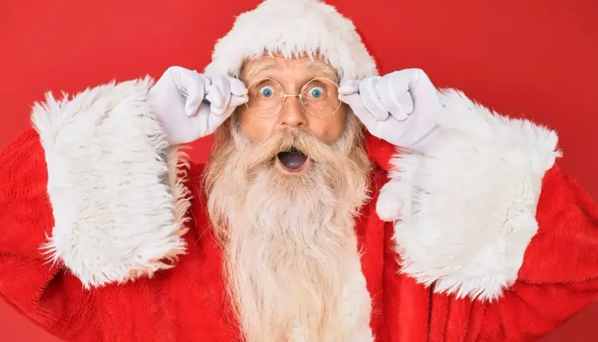 Babbo Natale, con gli occhi spalancati e le mani sui suoi occhiali rotondi, sembra sorpreso dalle parole del Natale.