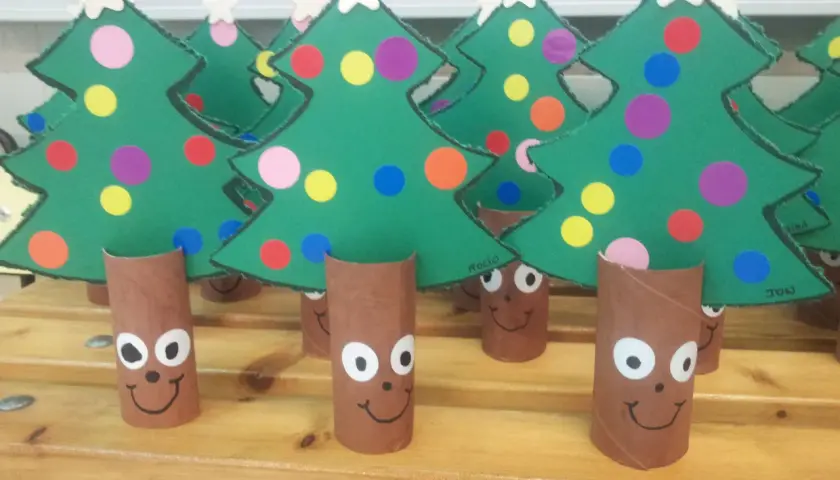 Arbolitos verdes decorados con círculos de colores y estrellas, listos para celebrar el día del árbol.