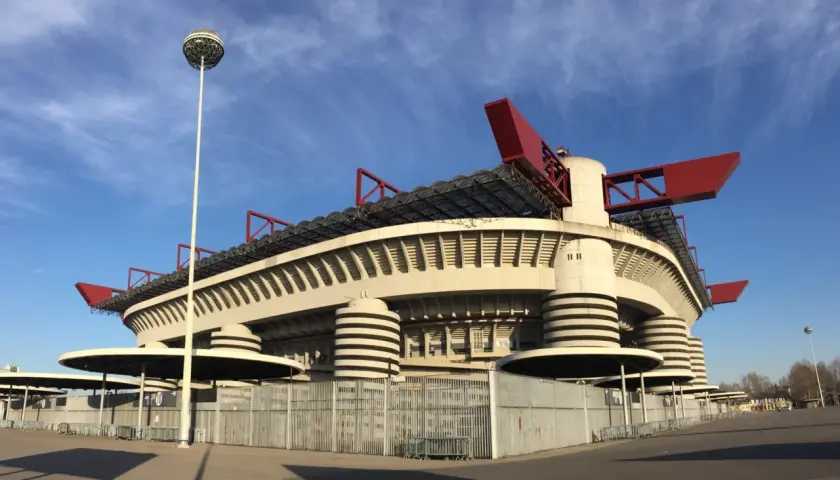Stadion San Siro z czerwonymi elementami dachu i charakterystycznymi wieżami. Marzenie o meczu i zakup san siro bilety.
