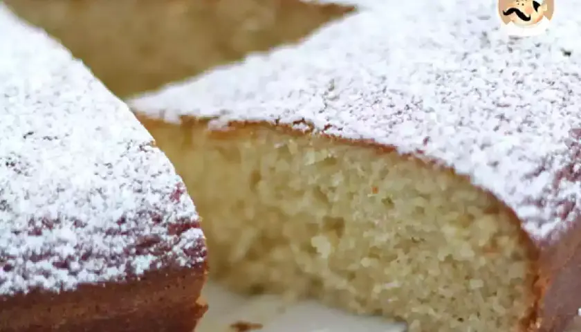 Una soffice torta allo yogurt, cosparsa di zucchero a velo, pronta per essere gustata.