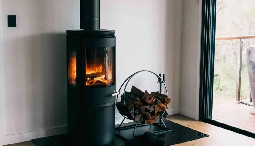 Poêle à bois moderne avec flammes vives et bûches. Une question se pose : peut-on installer un poêle à granule soi même ?