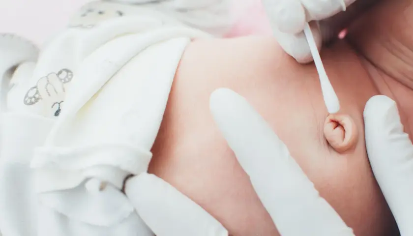 Delikatne czyszczenie pępka noworodka. Kiedyś to był pępowina, teraz to pamiątka po życiu w brzuchu mamy.