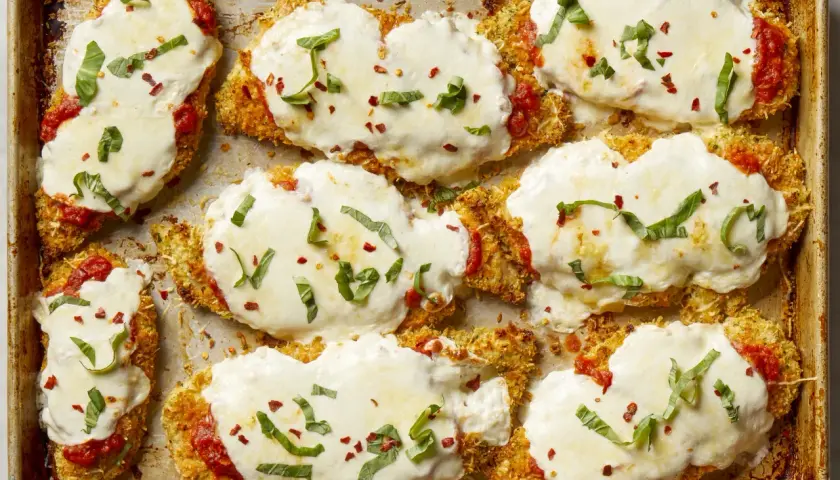 Cotolette di pollo impanate e gratinate con mozzarella filante, salsa di pomodoro e basilico fresco. Un elenco di cibi deliziosi pronti per essere gustati.