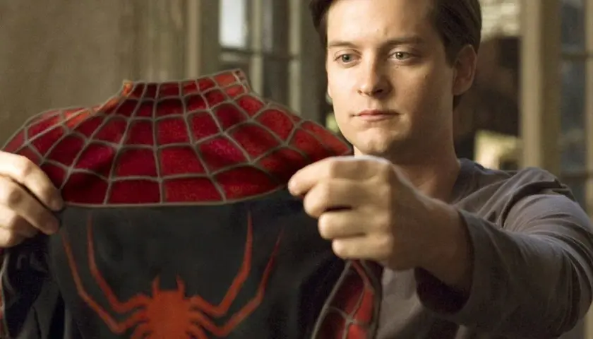 Tobey Maguire examine le costume de Spider-Man, un moment clé dans les films avec Tobey Maguire.