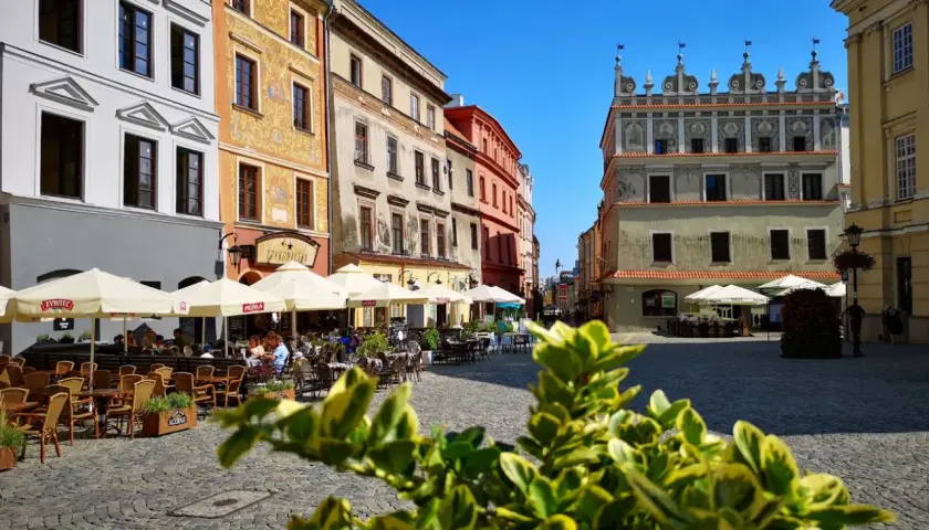 Tętniący życiem rynek w Lublinie. Kolorowe kamienice, kawiarniane ogródki i zabytkowa architektura tworzą urokliwy klimat.