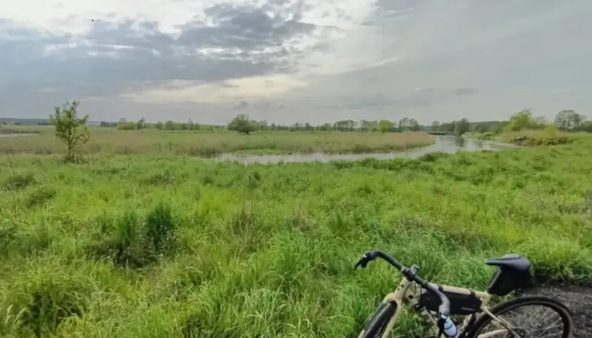Rower na tle łąk i rzeki, gdzieś w okolicy najwyższego pasma Gór Świętokrzyskich.