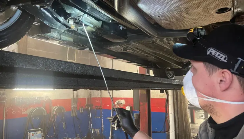 Mechanik aplikuje zabezpieczenie antykorozyjne podwozia. Sprawdź, jaka jest cena tej usługi i chroń swój samochód!