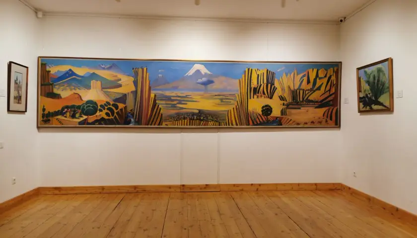 Paysage arménien aux couleurs vives, une œuvre de Martiros Saryan. Montagnes, ville et caravane de chameaux sous un ciel bleu intense.