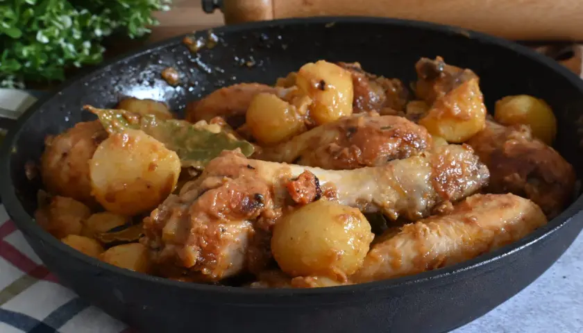Un saporito pollo in umido con patate e alloro, cotto in padella.