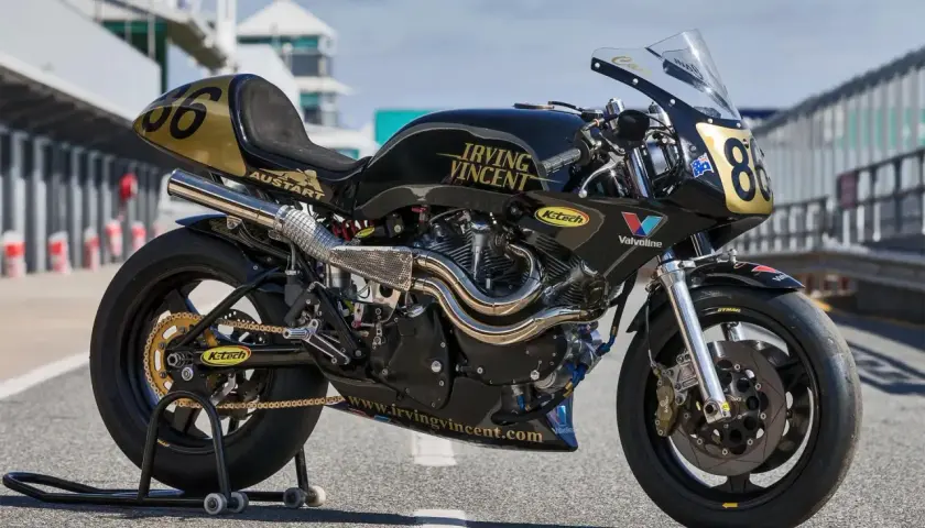 Motocicleta de carreras negra y dorada, modelo Irving Vincent, lista para la pista.