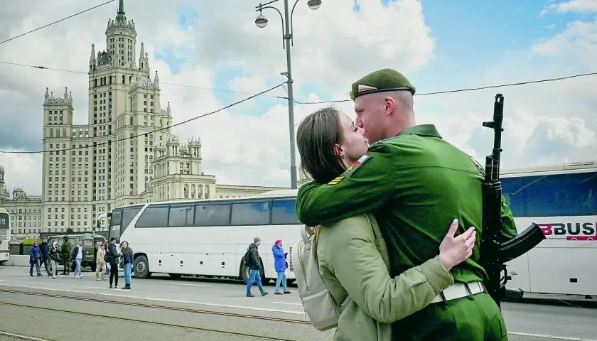 Żołnierz w zielonym mundurze, z karabinem na ramieniu, całuje ukochaną na tle moskiewskiego drapacza chmur. To nie jest sposób, jak podrywa ukrainiec, ale piękny moment pożegnania.