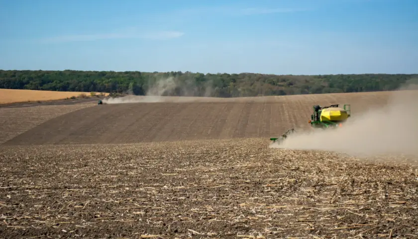 Traktor sieje na polu, wzbijając kurz. Czy umowę dzierżawy trzeba zgłosić do gminy? Pytanie to nurtuje rolników.