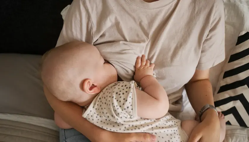 Un neonato si nutre al seno, un momento intimo che celebra il legame tra madre e figlio. Il ciclo della vita continua con l'allattamento.