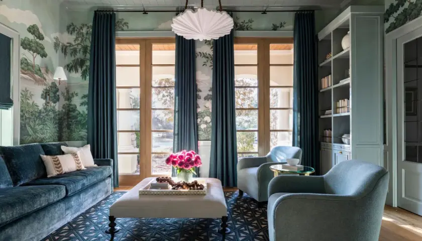 Elegant teal curtains frame French doors, showcasing a lush garden mural and reflecting current curtain trends.