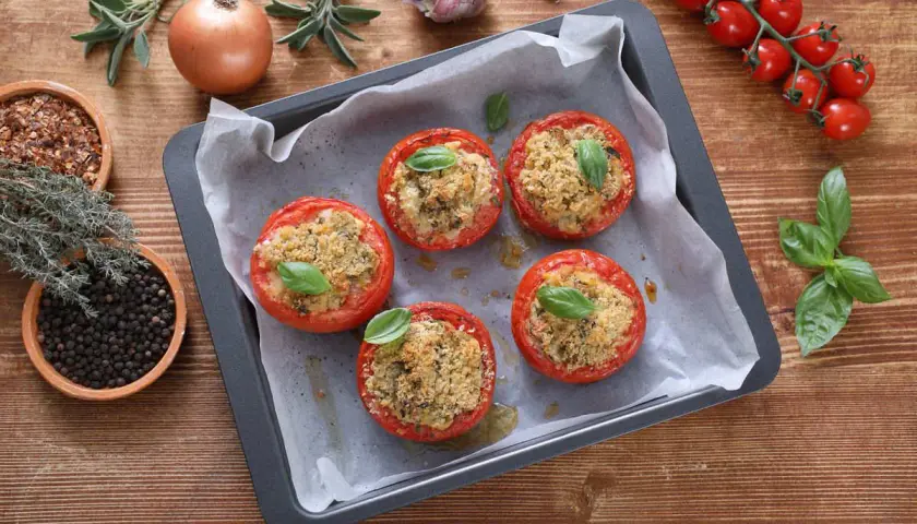 Pomodori ripieni in friggitrice ad aria, dorati e profumati, pronti per essere gustati.