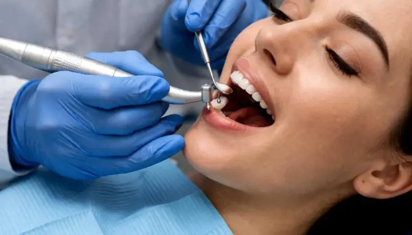 Dentysta zakłada plombę w zębie pacjentki.