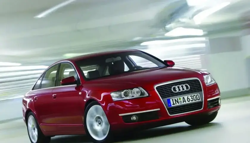 Czerwone Audi A6 C6 2.7 TDI w ruchu, z rozmytym tłem sugerującym prędkość.